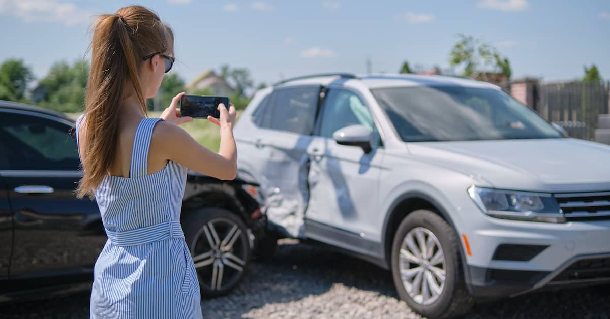 Woman taking pictures of a crash to determine car accident liability | Colombo Law